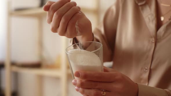 Closeup Cropped Shot of Female Artisan Pouring Dry Mixture By Hand Into Measuring Transparent Glass alt