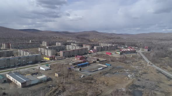 Aerial view of city with three-story and five-story houses. Spring, trees without leaves. 40 alt