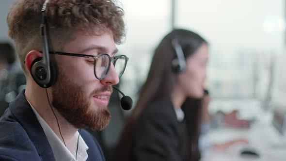 Close Up Portrait of a Technical Customer Support Specialist Talking on a Headset While Working on a alt