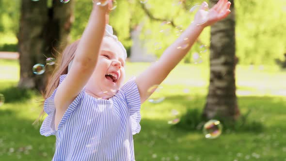 Little Girl Playing with Soap Bubbles at Park alt