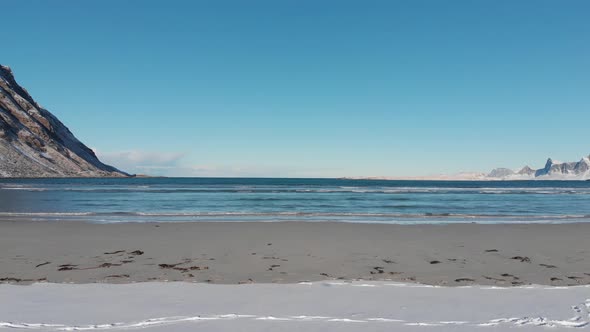 Snow on the beach and on the sand with arctic ocean horizon