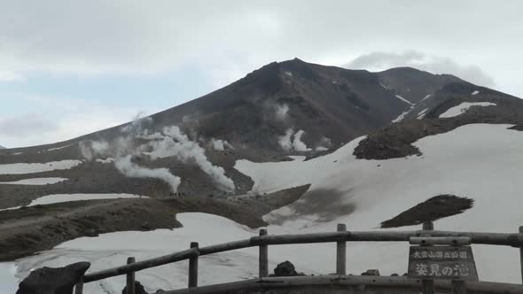 Small people walking in line on grand, snowy, foggy mountain, Mt. Asahidake, Japan, Extreme Wide Sho alt