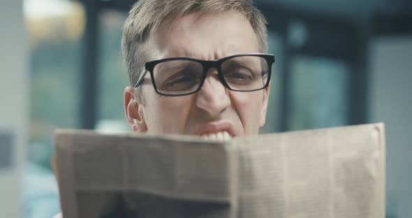 Man reading a newspaper and having a vision problem