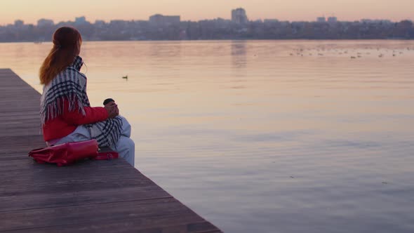 Side view of young woman with paper cup of coffee alt