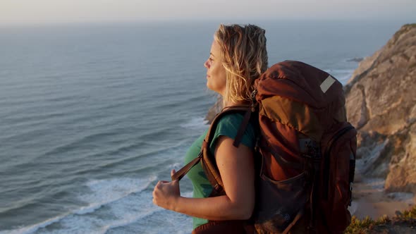 Happy Middle Aged Woman Wearing Camping Backpack alt