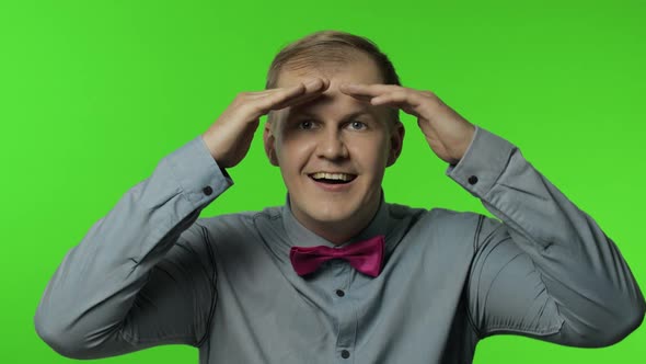 Man Holding Hand Above Eyes, Looking Far Away Into Distance with Attentive Searching Someone alt