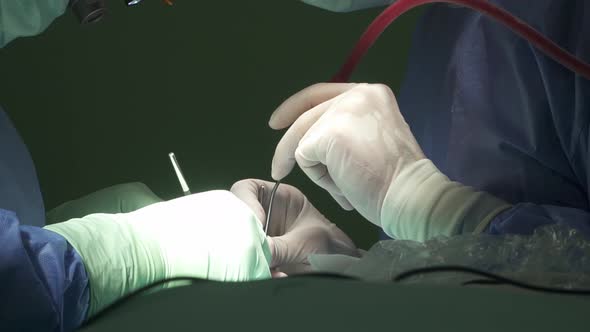 Unrecognizable medics performing surgery in operating room alt