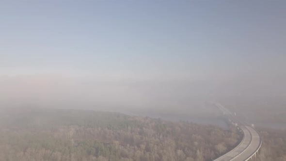 Flight Over the Bridge in the Early Sunny Morning During Fires Covered in Smoke in Autumn Outside