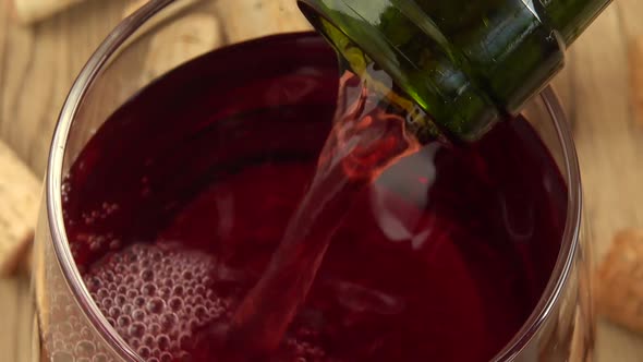 Wine is poured into a glass on the background of wine corks. alt