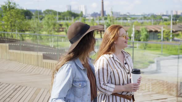 Stylish Women with Coffee Walk Along Contemporary City Park