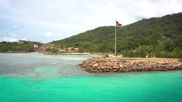 The Flag of Seychelles in the Port of La Digue Island alt