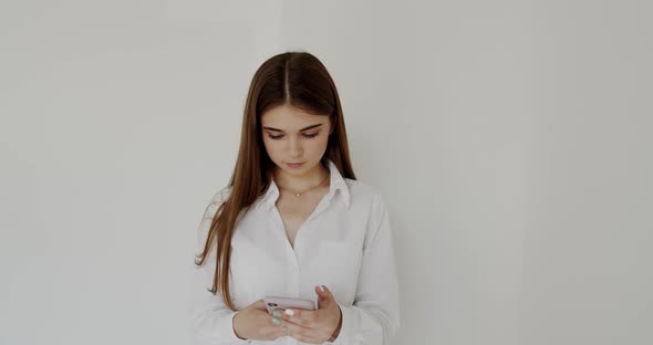 Portrait of Young Girl Staring on the Mobile Phone and Typing on It alt