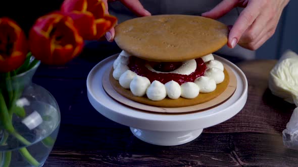 On the Cake Which is Decorated with White Cream and Red Raspberry Jam the Pastry Chef Puts the Cake