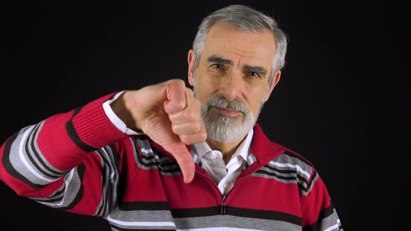 An Elderly Man Shows a Thumb Down To the Camera and Shakes His Head - Black Screen Studio alt