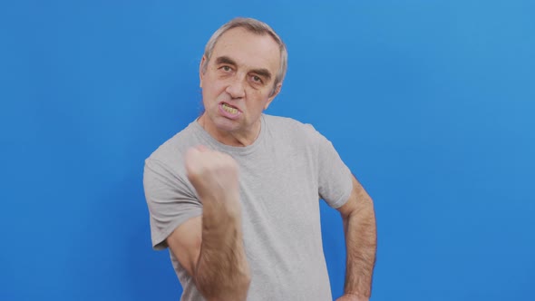 Senior Man Showing Fist To Camera Aggressive Facial Expression alt