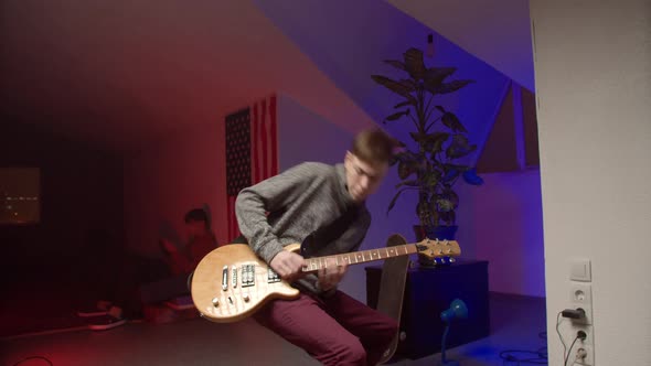 Energetic Young Man Playing Rock Music on Guitar