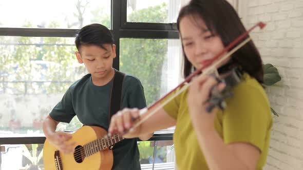 Asian mother and son live at home. The couple enjoyed playing music together. alt