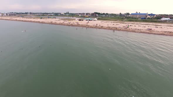 Aerial Shot of Black Sea Beach with Tourists, Sunshades, Hotels and Greenery