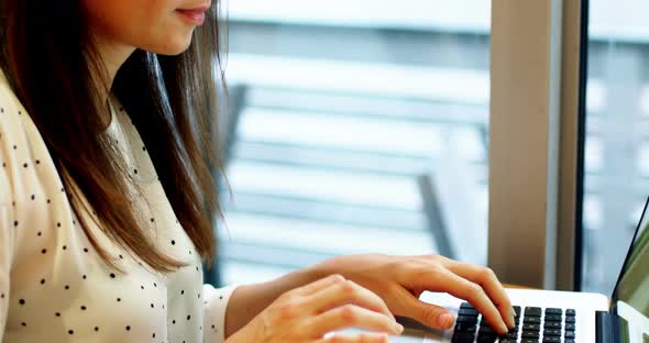 Attentive businesswoman using laptop alt