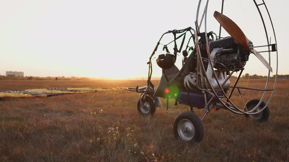 Motor Paraglider Stands at the Airport in the Rays of Sunset Sunlight. The Camera Moves Along the alt