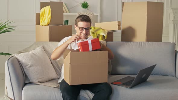 A Happy Man Satisfied By a Quick Delivery. Unpacking of Order From Online Shops. alt
