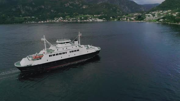 Aerial Slomo Panning around a Norwegian Ferry entering a Small Village alt