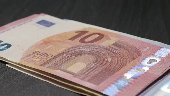 Wad of combined Euro money banknotes on table drop on table 4K 3840X2160 UHD video - European Union 