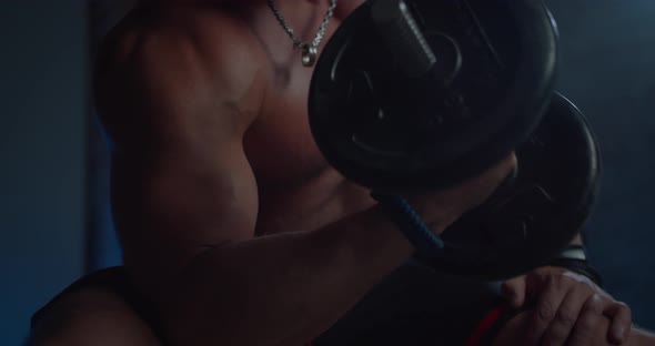 Close Up Shot of Handsome Fitness Man Shirtless Bodybuilder Trains Biceps with Dumbbell in Hands in