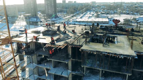 Builders Work on a Construction Site with a Crane. alt