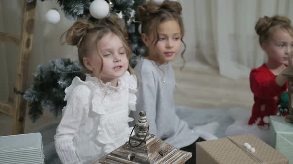 Happy American family celebrating Christmas. Children open a gift at home. alt