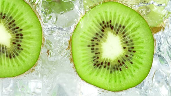Super Slow Motion Shot of Pouring Water on Sliced Kiwi and Ice Cubes in Glass at 1000 Fps alt