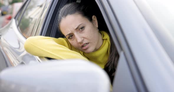 Woman driving a car and getting annoyed stuck in traffic