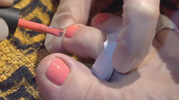 The Pink Nail Polish on the Nails of the Toes