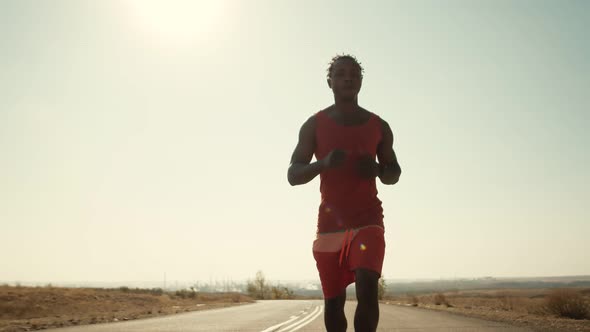 AfricanAmerican Man Runs Along Road Doing Daily Workout and Checks His Pulse on Smart Watch Front alt
