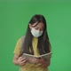 Asian Girl Student Wearing A Mask, Holding And Looking Book While Walking To School On Green Screen - VideoHive Item for Sale