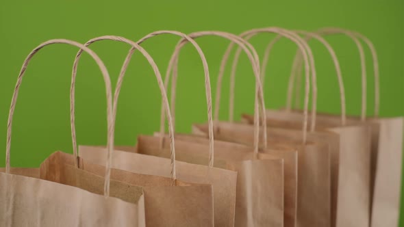 Paper package bags for shopping or delivery isolated on green background alt