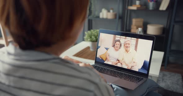 Young Asia girl using laptop video call meeting talk with elderly family dad and mom. alt