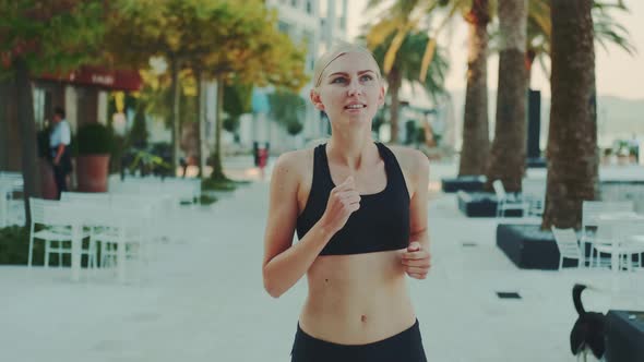 Attractive Blonde Woman in Fitness Suit Jogging on the Street