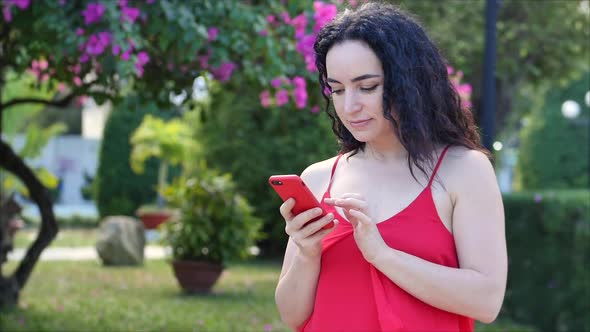 European Young Girl or Woman Cute Cheerful Girl Brunette Typing Texting on the Smartphone, Woman alt