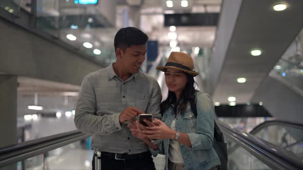 Couple Asian people walking in airport terminal waiting for  flight boarding.