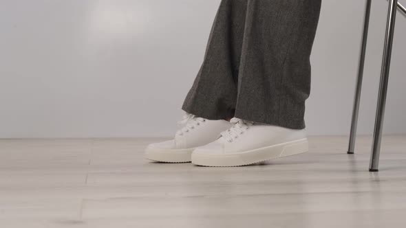 Business Woman Takes Off White Leather Sneakers and Puts on Black High Heel Shoes alt