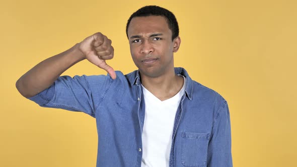 Young African Man Gesturing Thumbs Down, Yellow Background alt