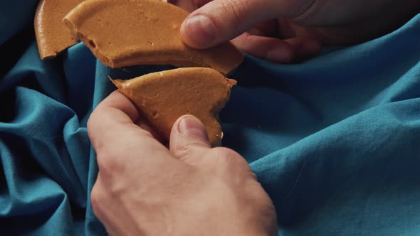 Men's Hands Break Sugar Cookies Candy in the Shape of a Heart
