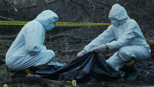 Forensic specialists working in the forest. Crime scene and police concept. alt