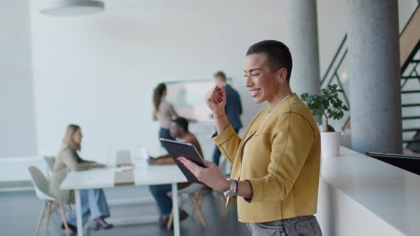 Young short hair business woman standing in the office and using digital tablet