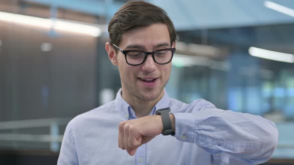 Portrait of Young Man Attending Call on Smart Watch alt