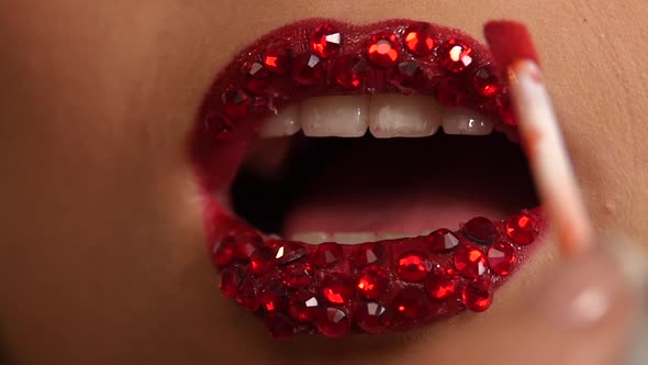 Luxury Woman with Rhinestones on Her Lips. Slow Motion. Close Up alt