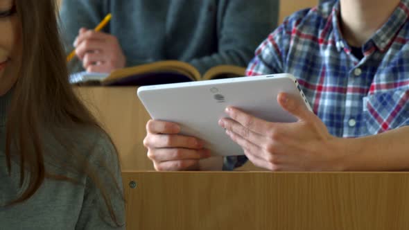 Male Student Shows His Classmate Something on Tablet