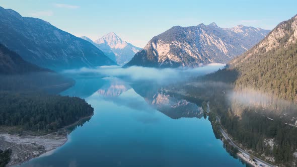 Plansee, Tyrol, Austrian Alps - 4K 24fps Aerial - Flying Above the water and a sea of fog