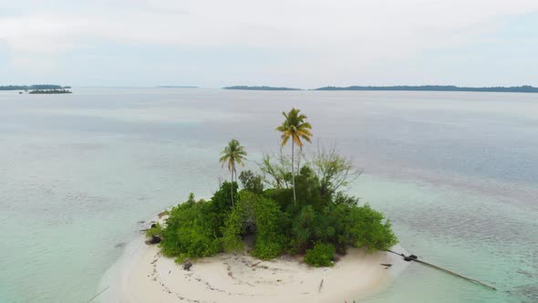 Aerial: flying over desert island tropical beach caribbean sea coral reef sunset alt